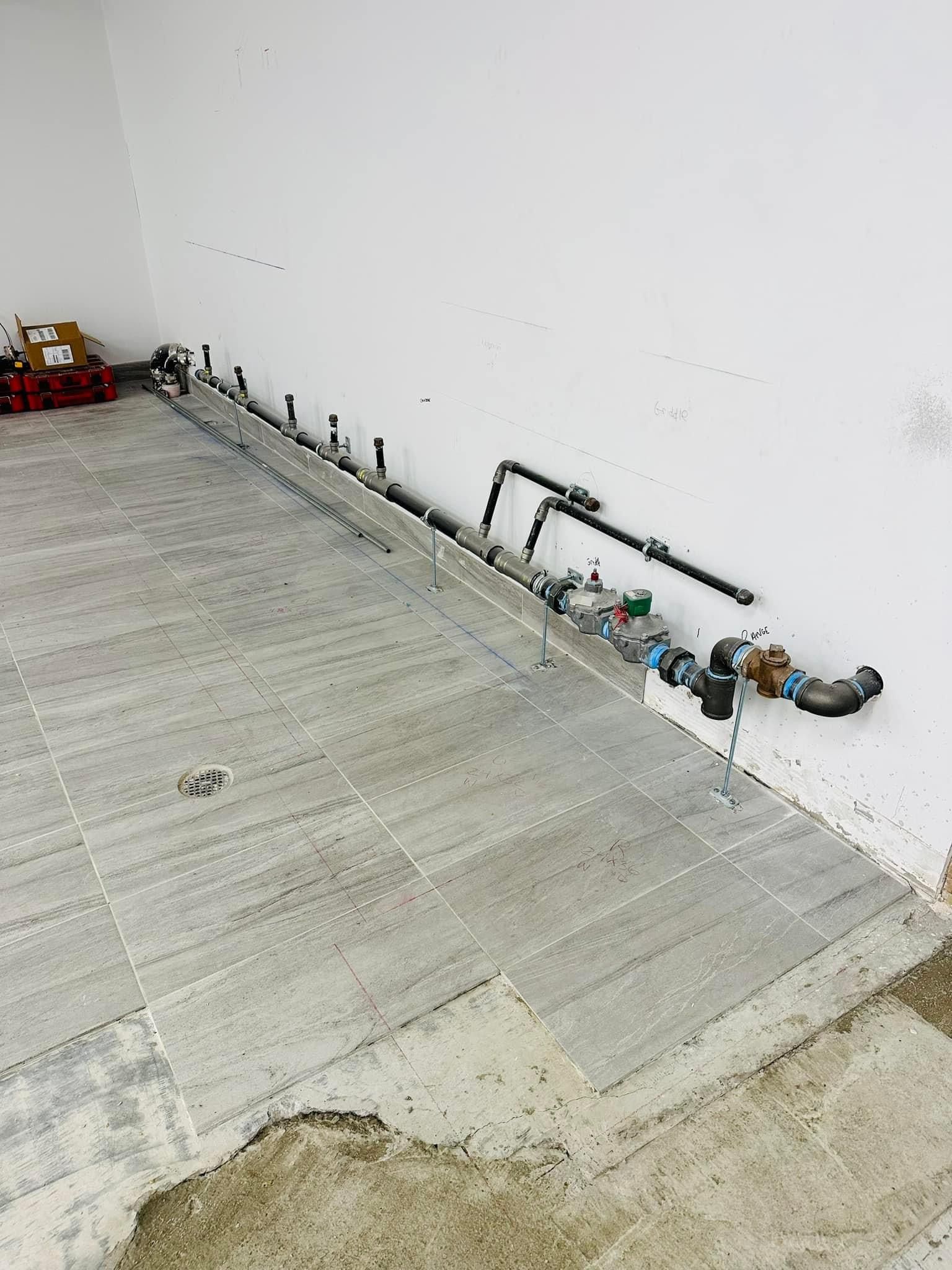 a room with a lot of pipes hanging from the wall