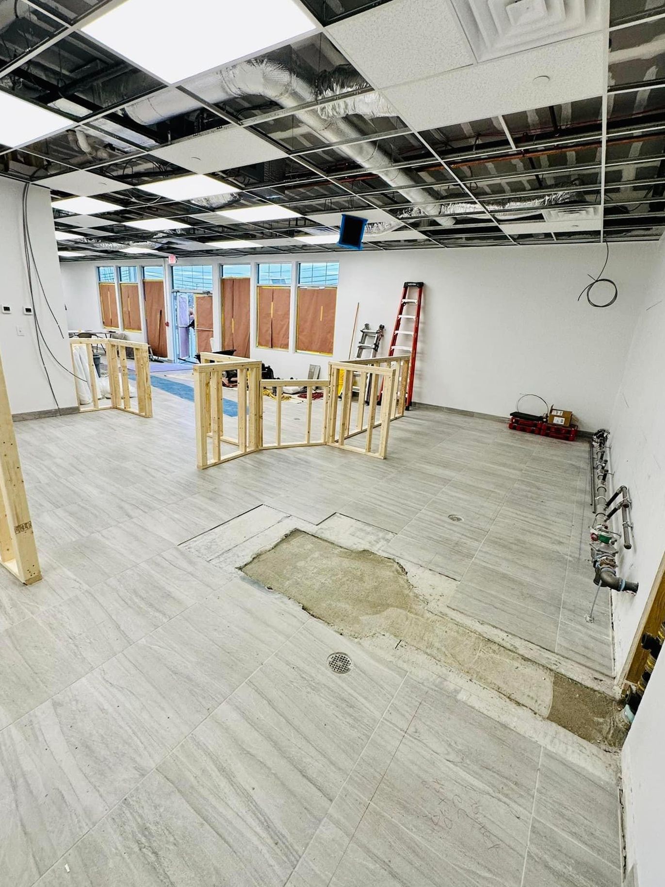 a large room with a ladder in the middle of it is being remodeled