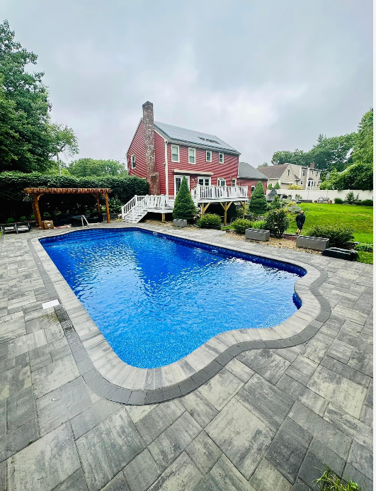 a large swimming pool is in the backyard of a house