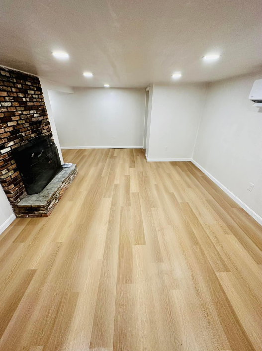 a living room with hardwood floors and a fireplace
