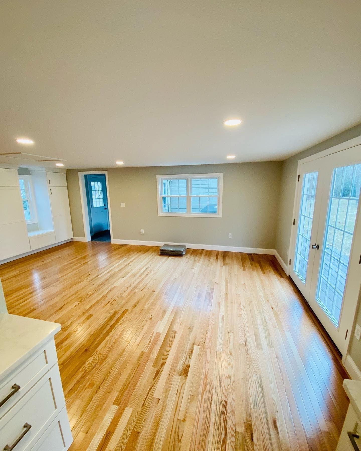 an empty living room with hardwood floors and sliding glass doors