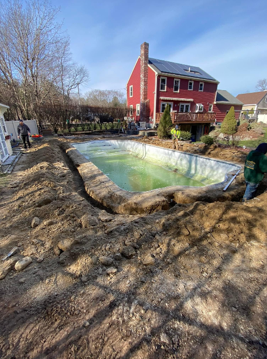 a large swimming pool is being built in the backyard of a house