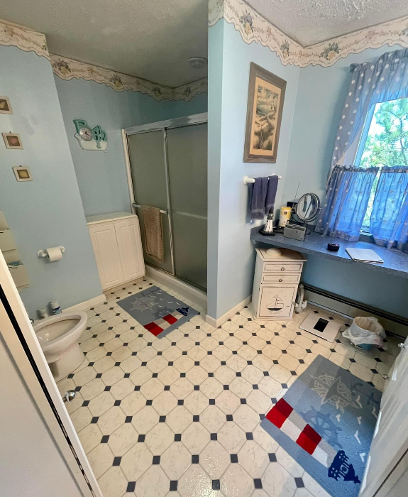 a bathroom with a toilet, sink, and shower