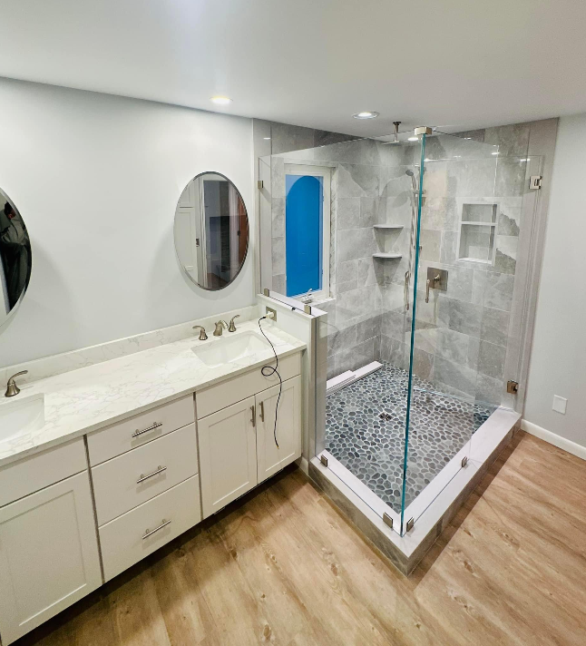 a bathroom with a walk-in shower, sink and mirror