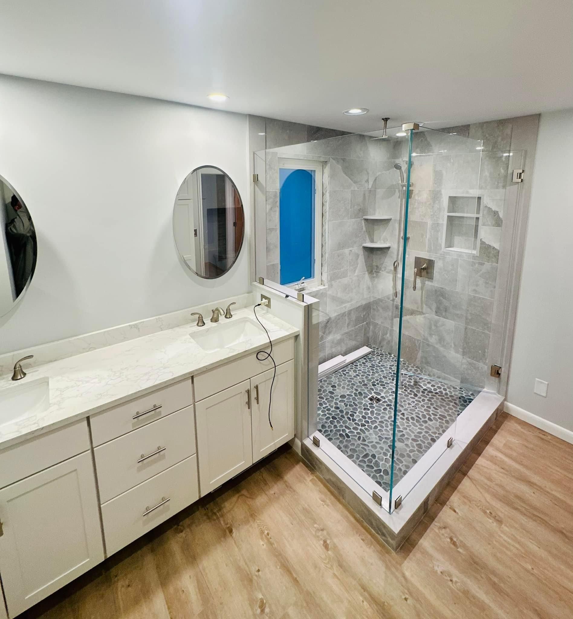 a bathroom with two sinks and a walk in shower