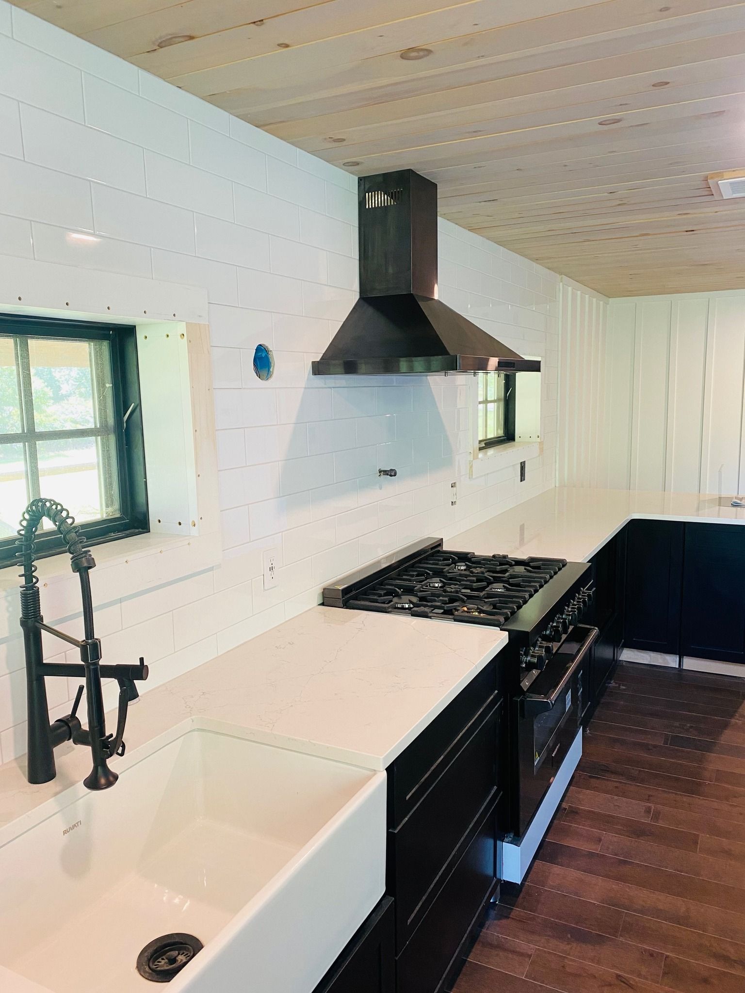 a kitchen with a sink, stove and hood
