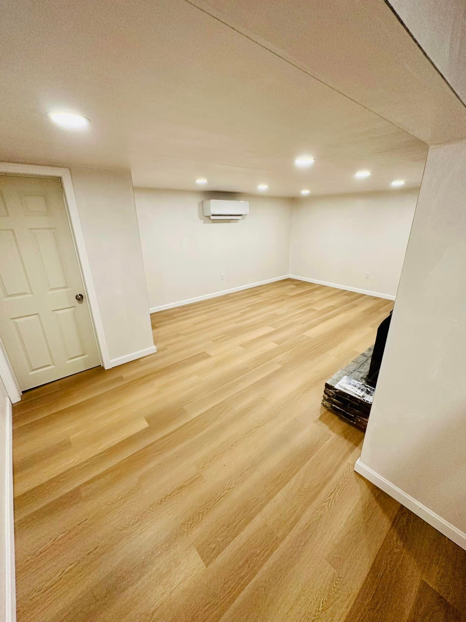 a large empty room with hardwood floors and white walls