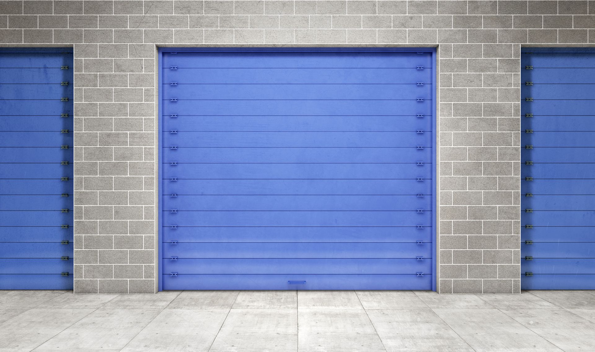 A large blue industrial garage door flanked by two smaller blue doors on a gray concrete block wall.