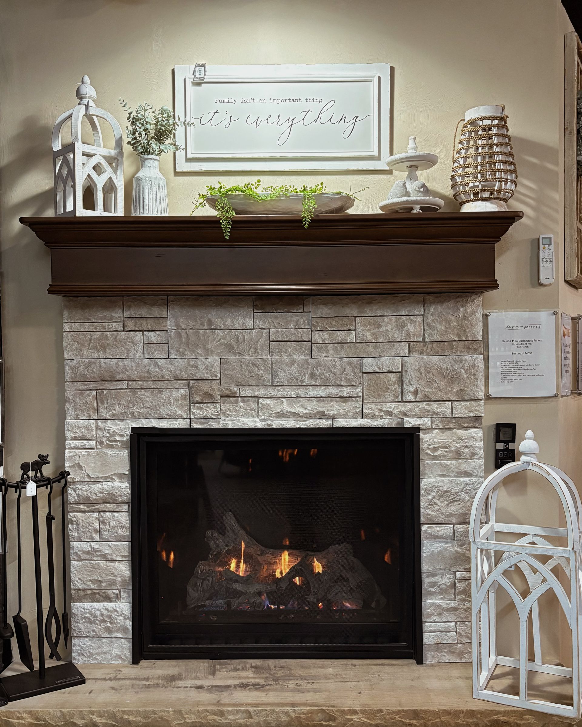 A living room with a fireplace and a painting on the mantle.