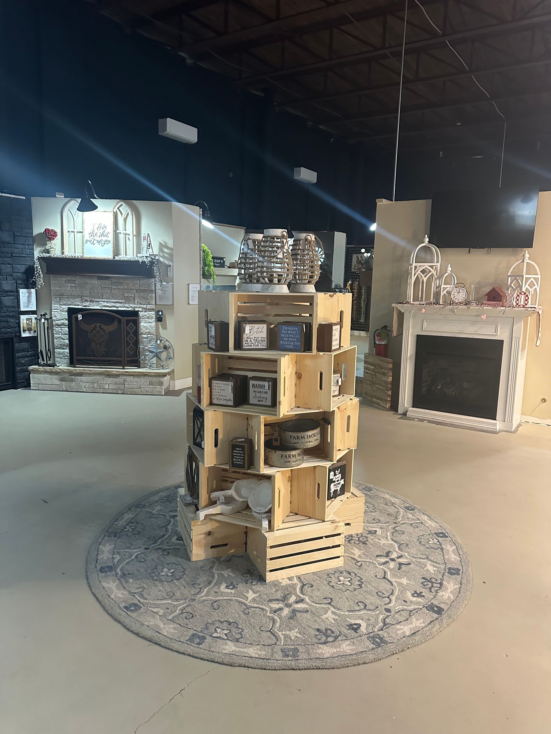A display of wooden crates in a room with fireplace mantels.