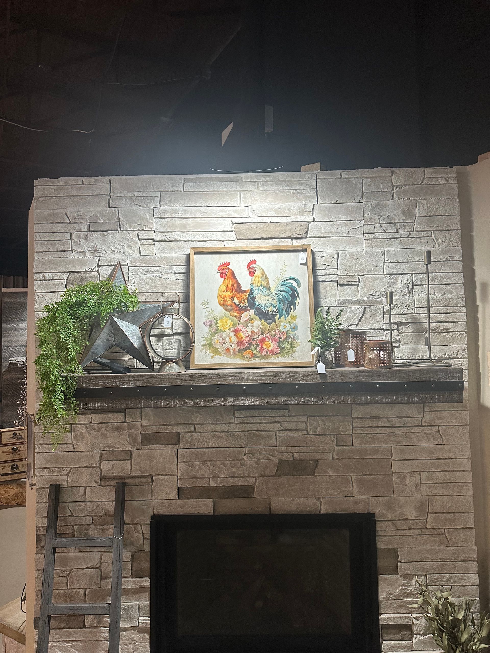 A fireplace with a painting of chickens on the mantle.