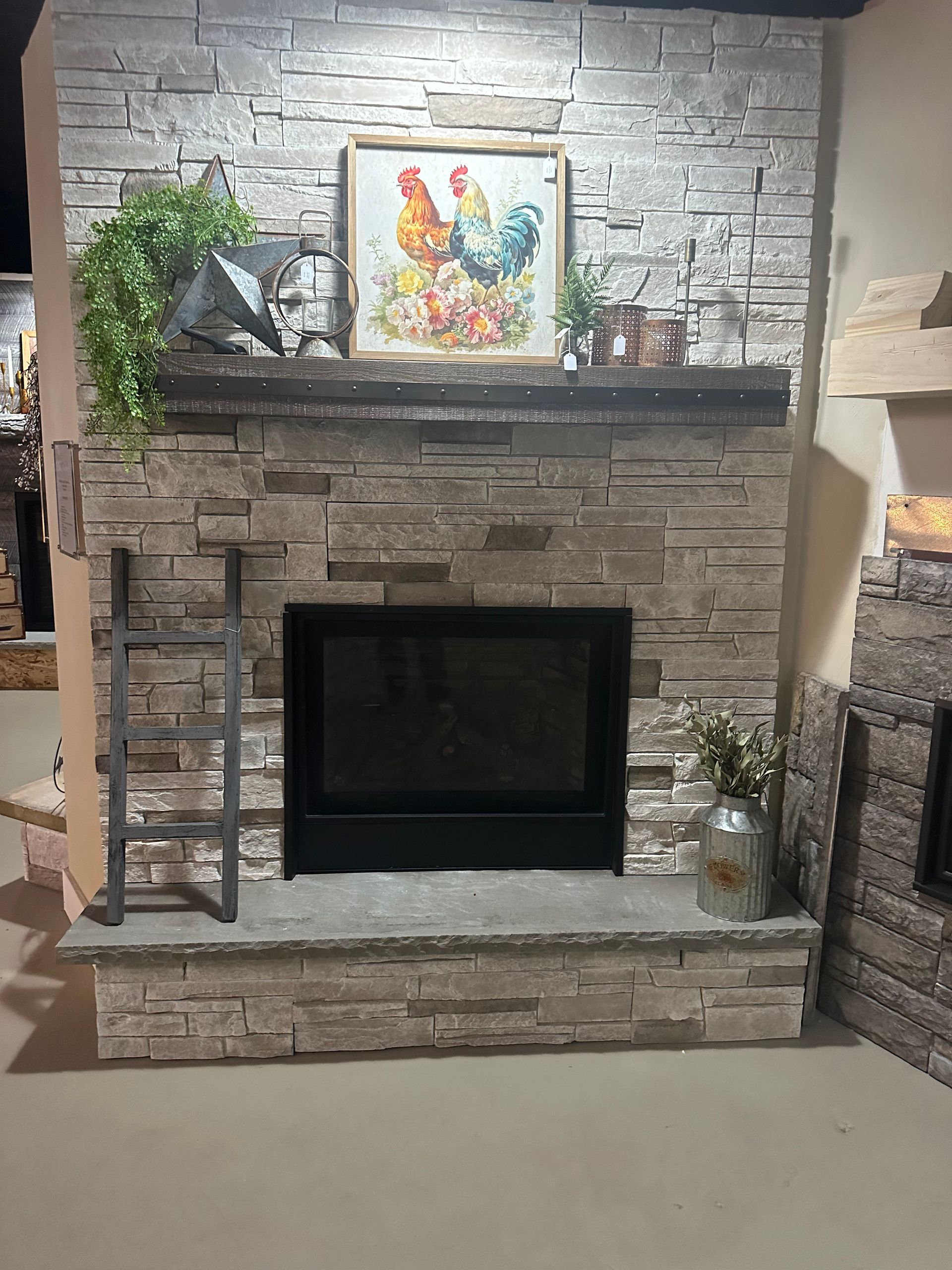 A living room with a fireplace and a painting on the mantle.