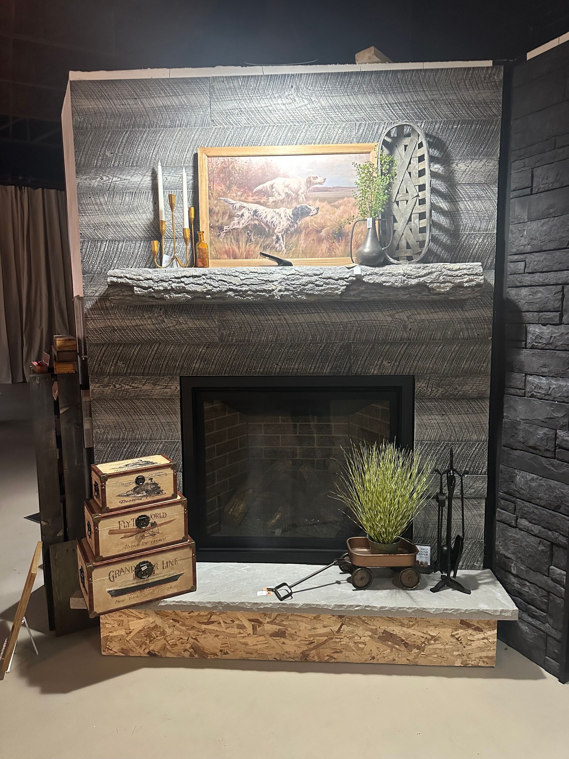 A fireplace with a picture on the mantle and a painting on the wall.