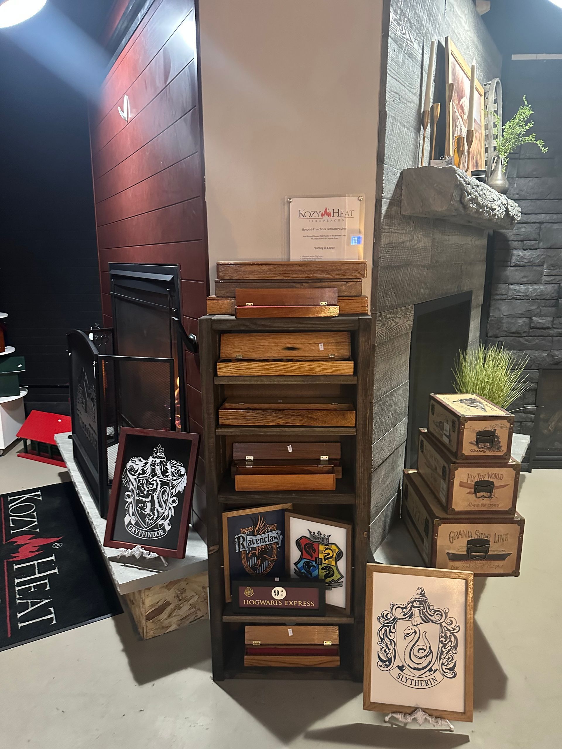 A room with a fireplace and a stack of boxes on a shelf.