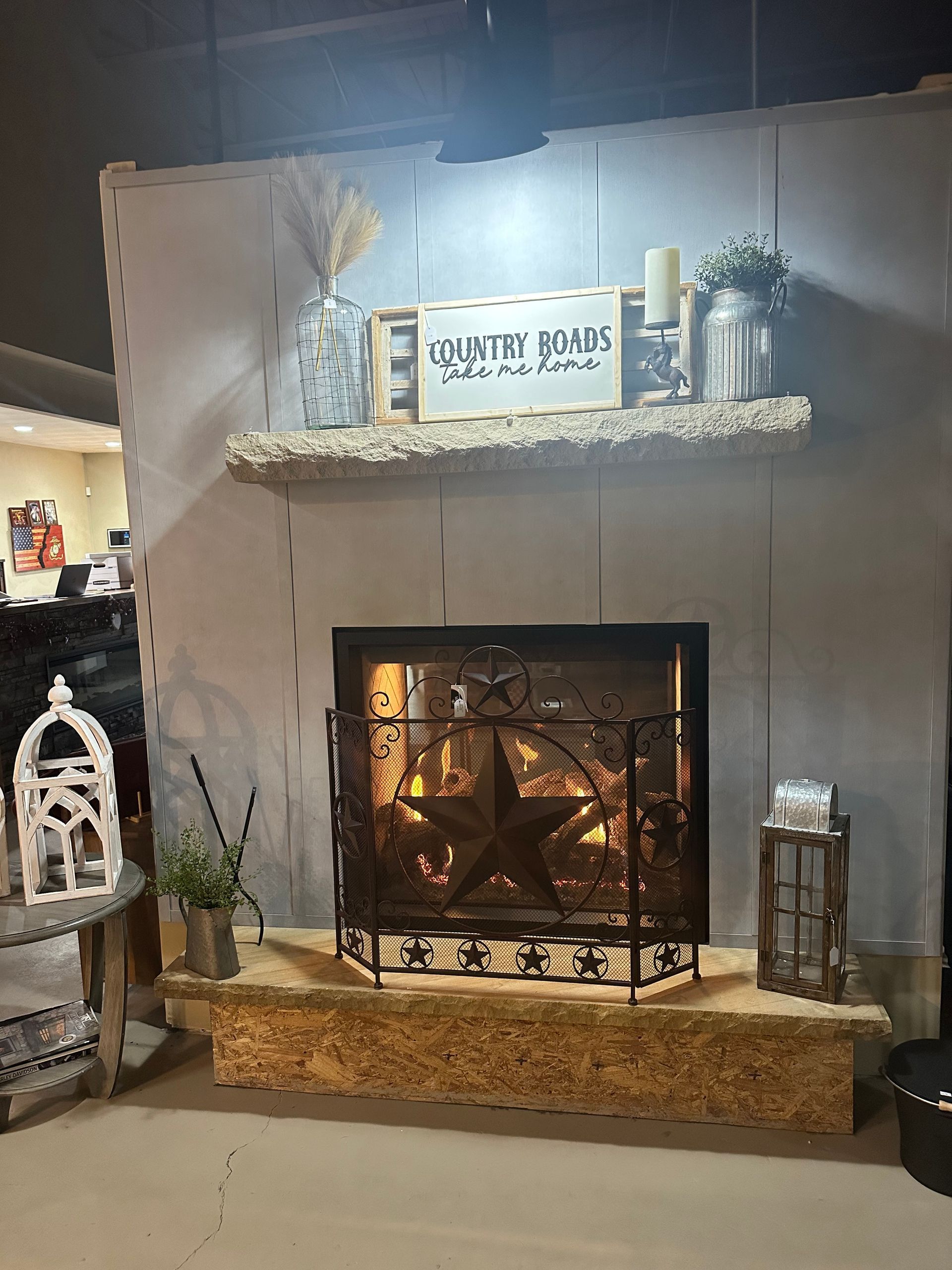 A living room with a fireplace and a shelf with a sign on it.