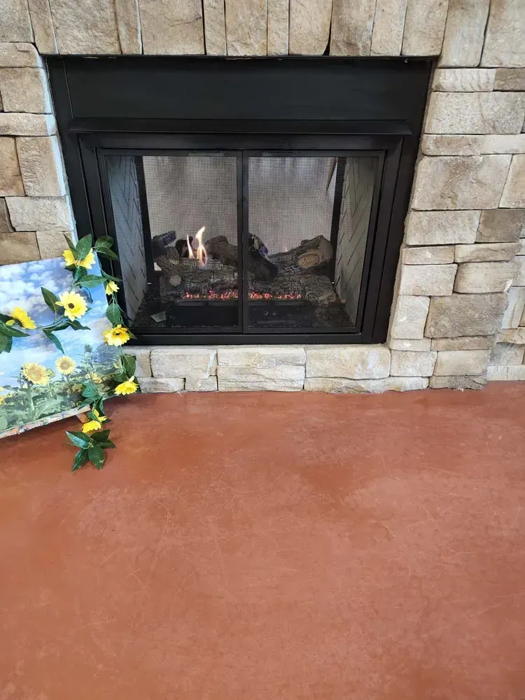 A fireplace with a picture of sunflowers in front of it.