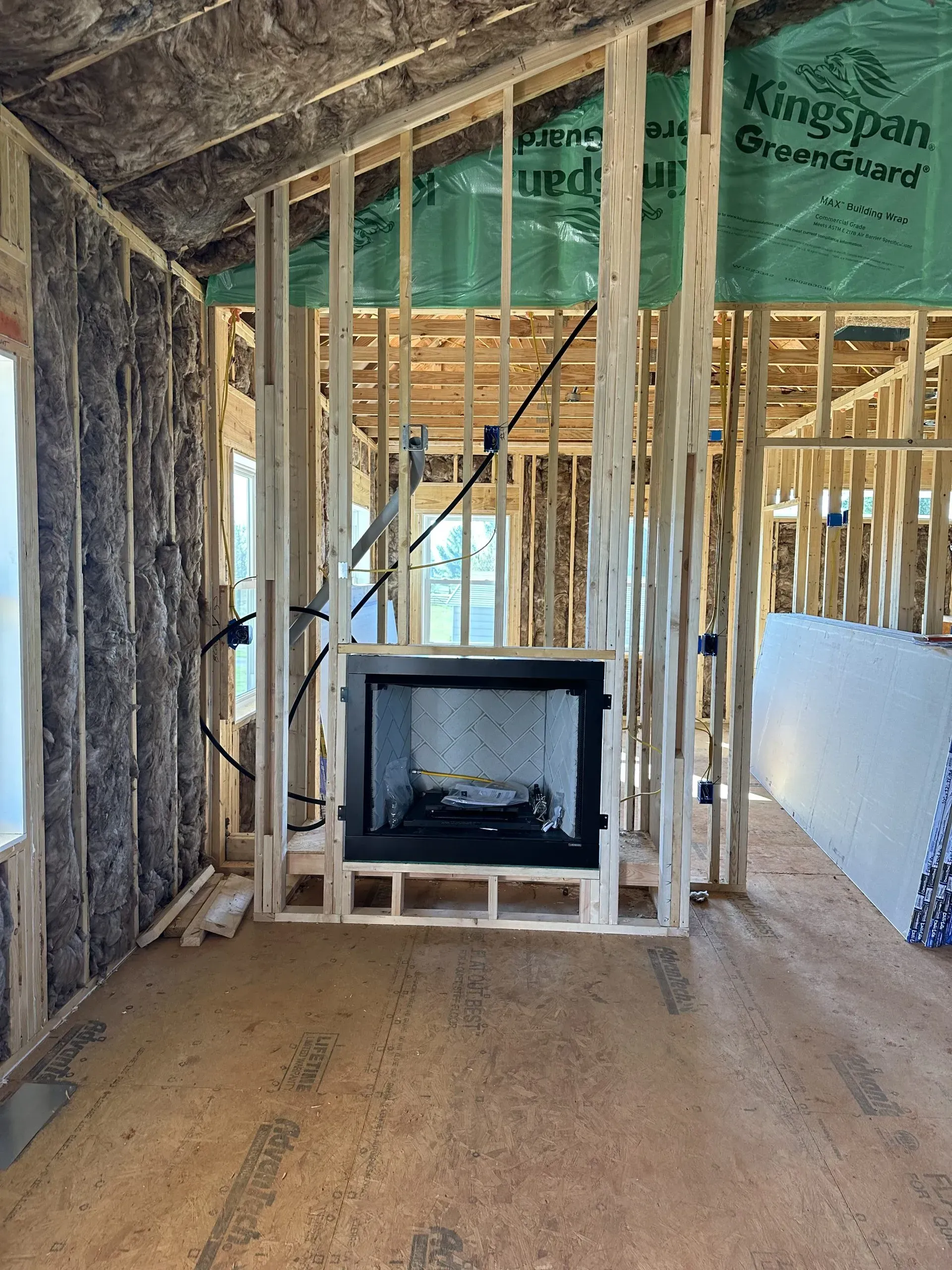 A fireplace is built into the wall of a house under construction.
