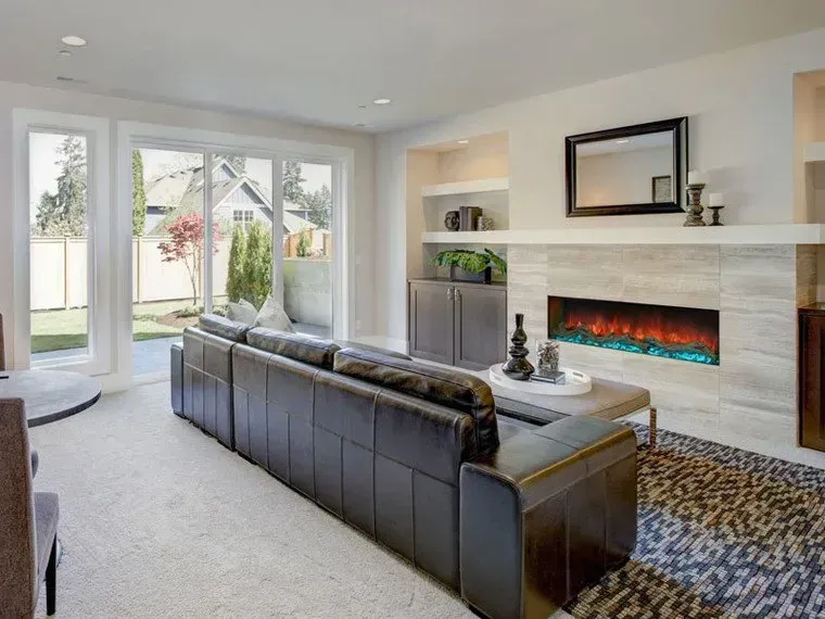 A living room with a couch , fireplace , and sliding glass doors.