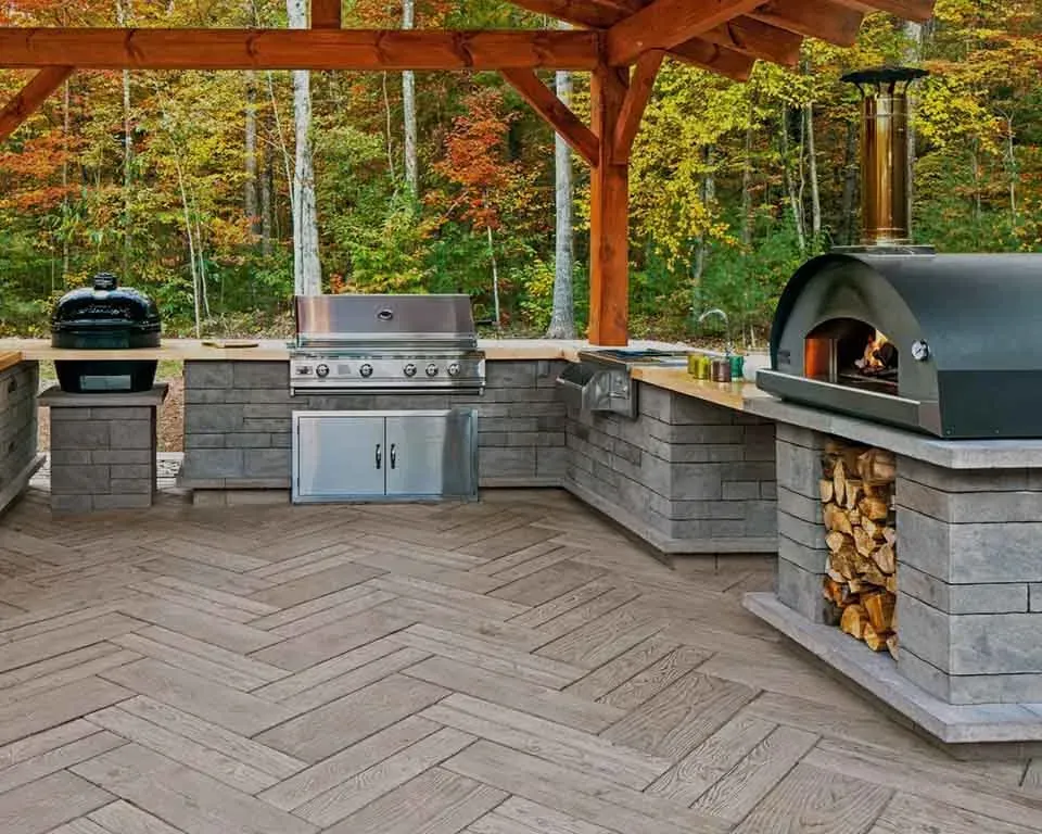 An outdoor kitchen with a pizza oven and a grill