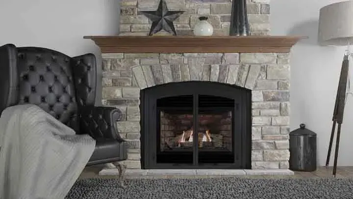A living room with a fireplace , chair and lamp.