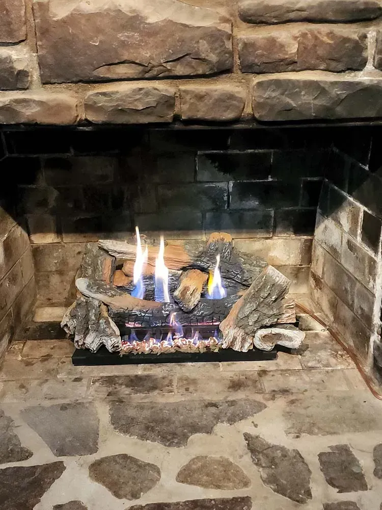 There is a fireplace with a lot of fire in it.