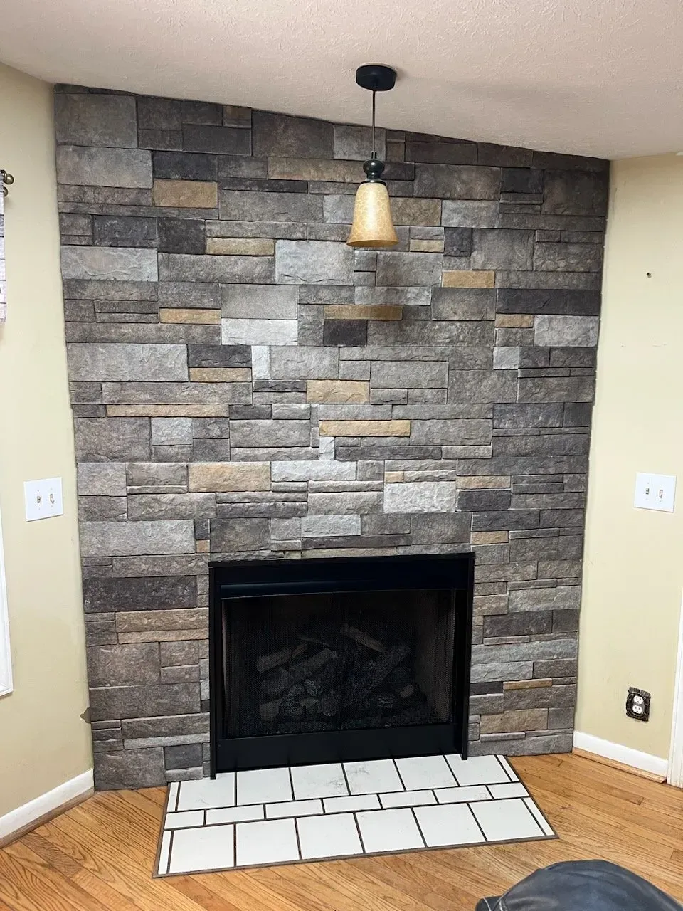 A living room with a fireplace and a stone wall