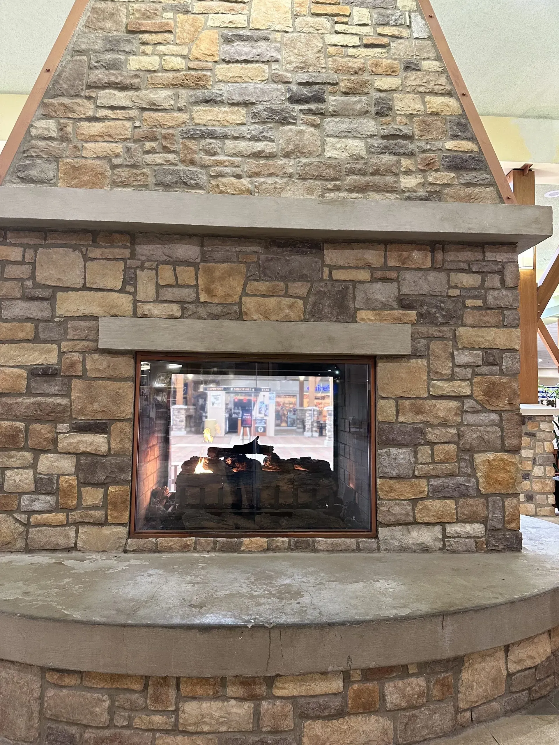 A large stone fireplace with a man standing in front of it