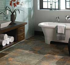 Bathroom with bathtub, dark wood vanity, and tiled floor.