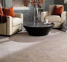 Living room with beige chairs, orange pillows, and a black coffee table on light-colored flooring.