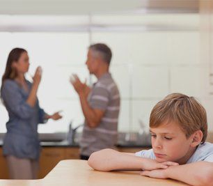 Sad little boy hearing his parents having am argument