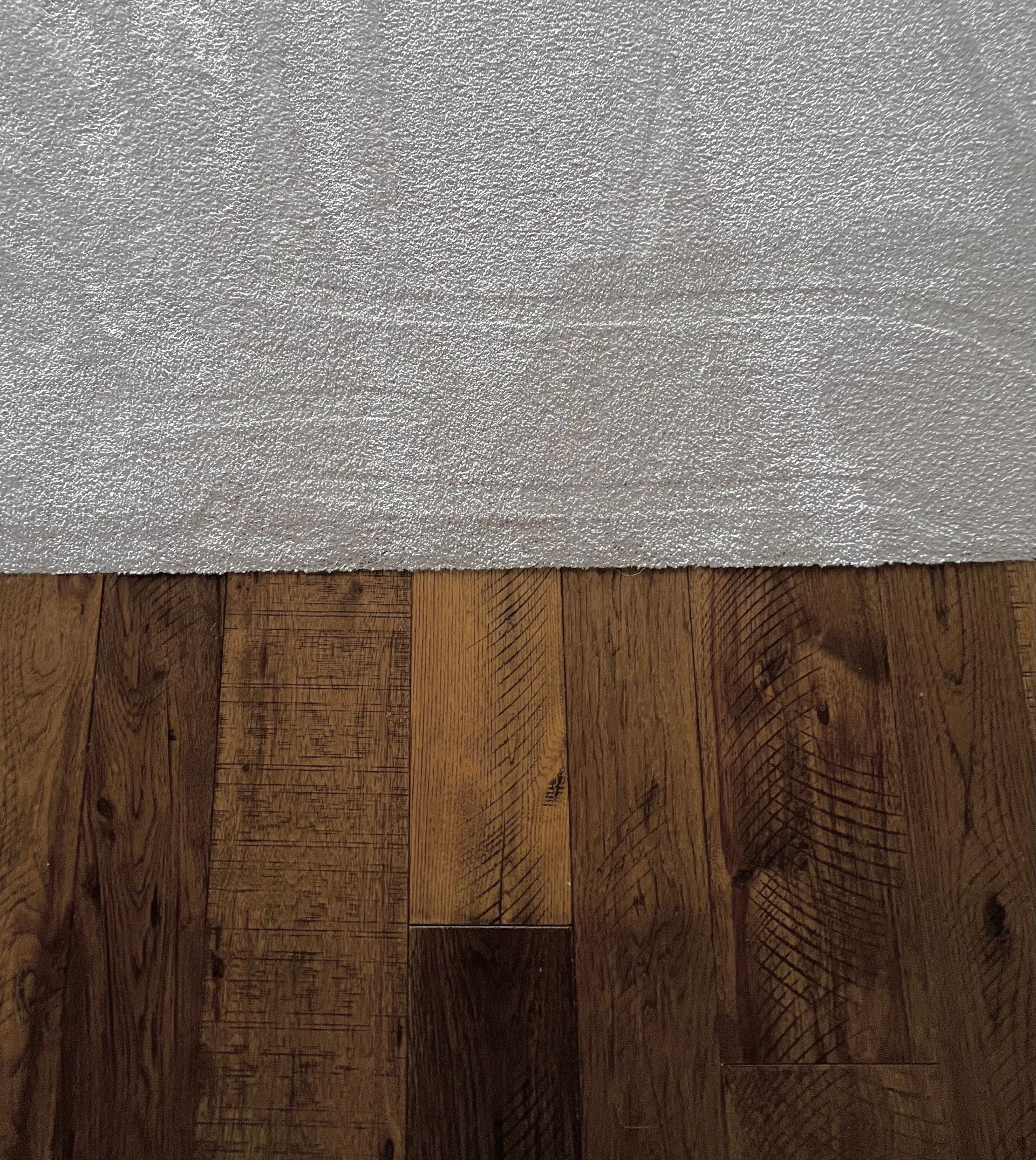 A split-view image showing a silver glittery texture on top and dark, distressed wood planks on the bottom.