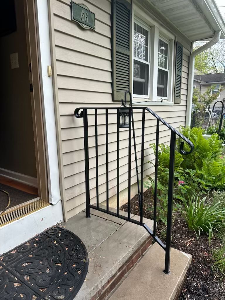 Front porch with black exterior stair safety railing for mobility access