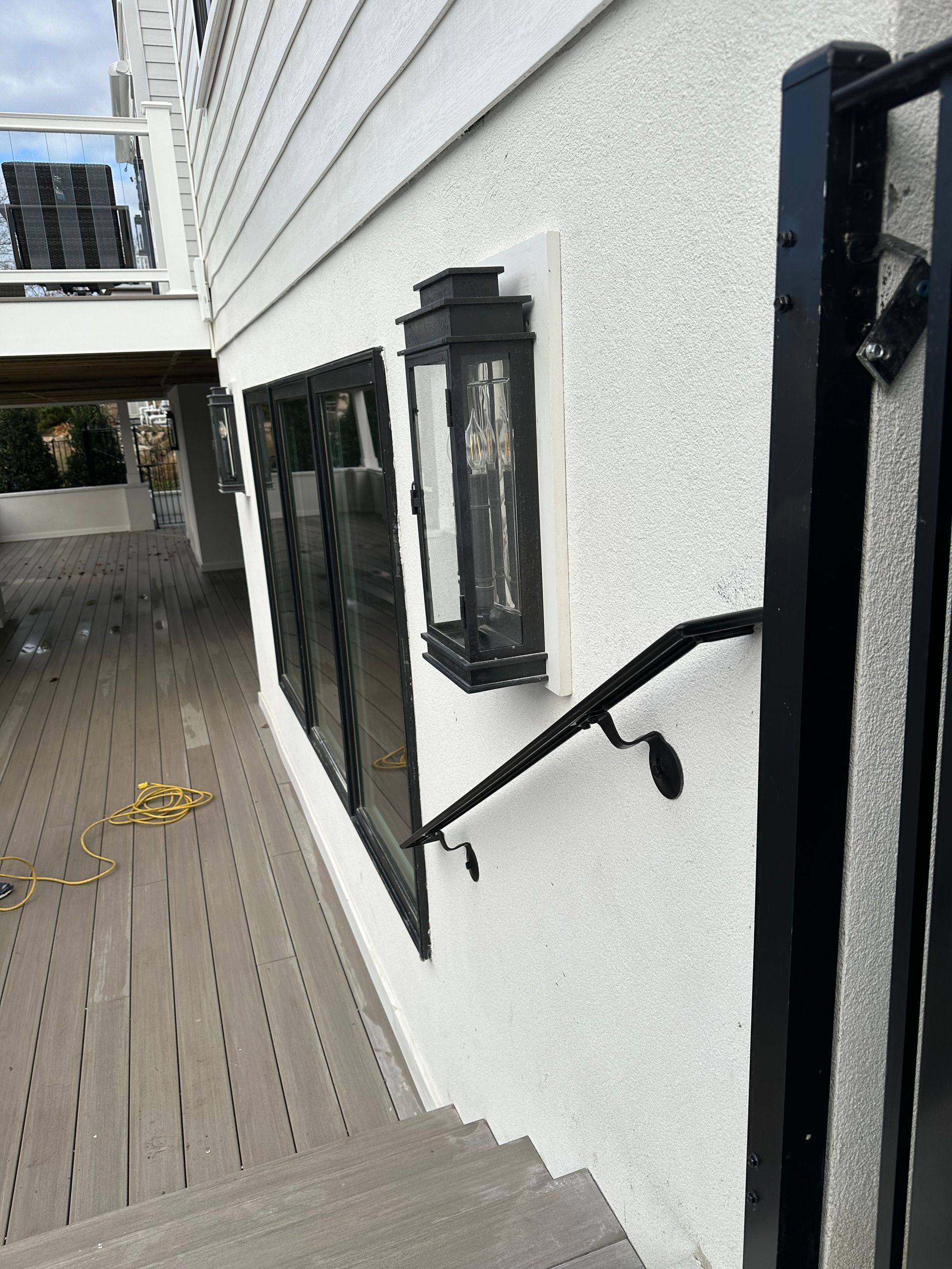 Exterior walkway beside a white building with black ADA accessibility handrail installation in New Jersey