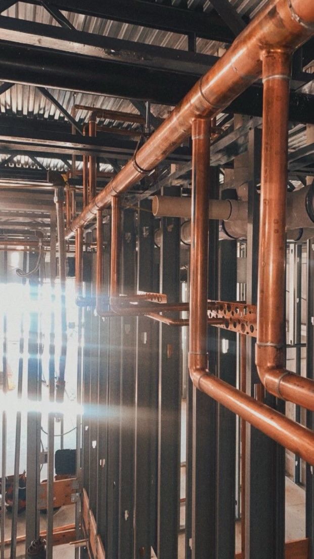 Copper pipes are lined up in a building under construction