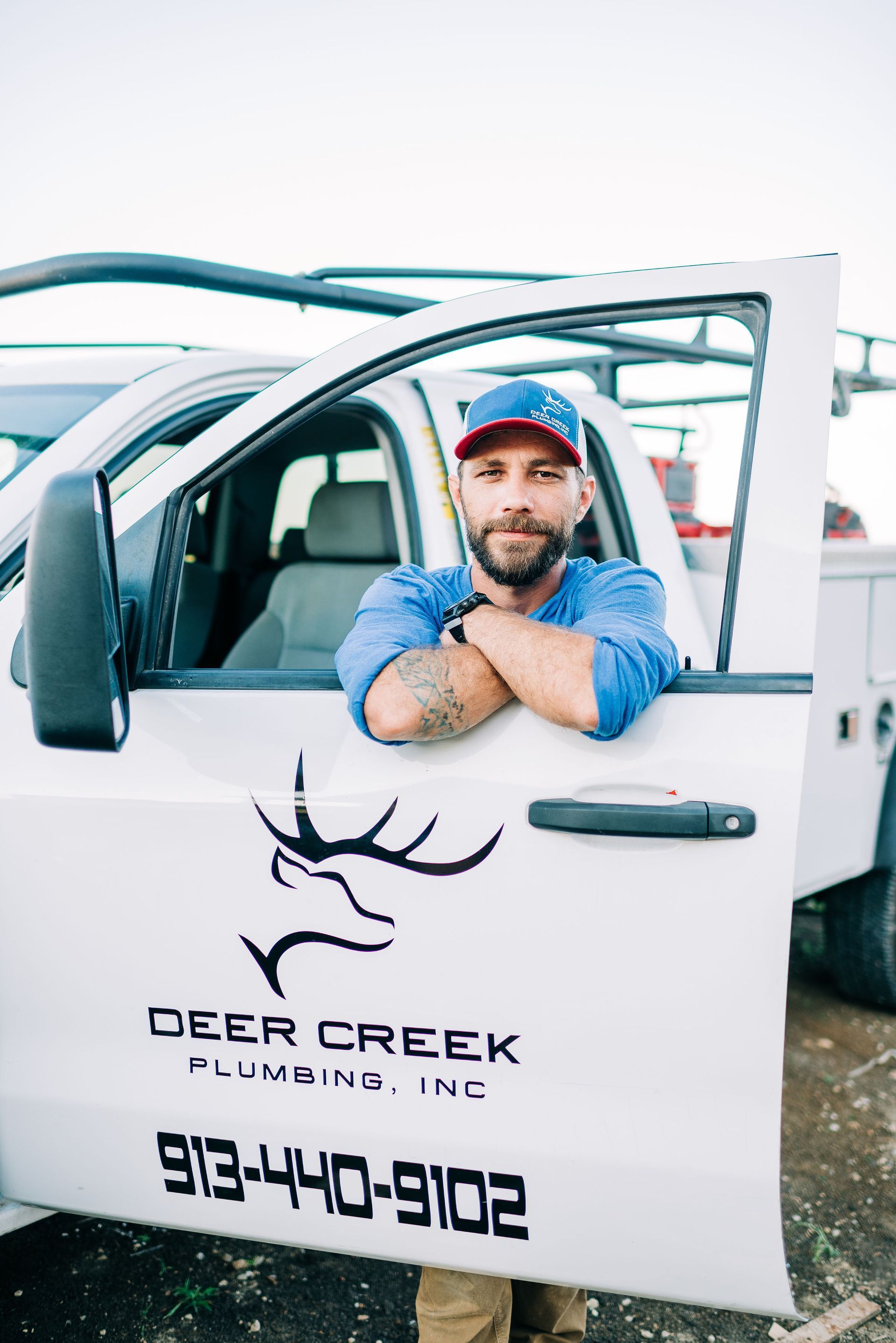 A man is leaning on the door of a white truck.