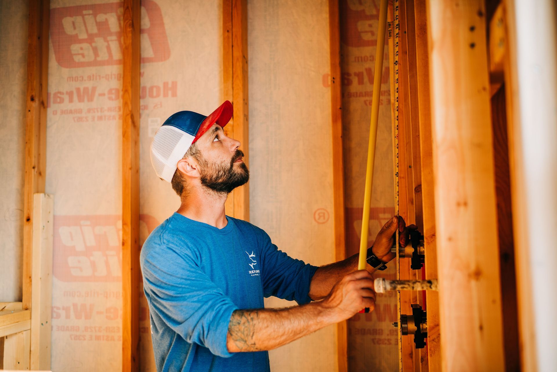 A man is measuring a pipe with a tape measure.
