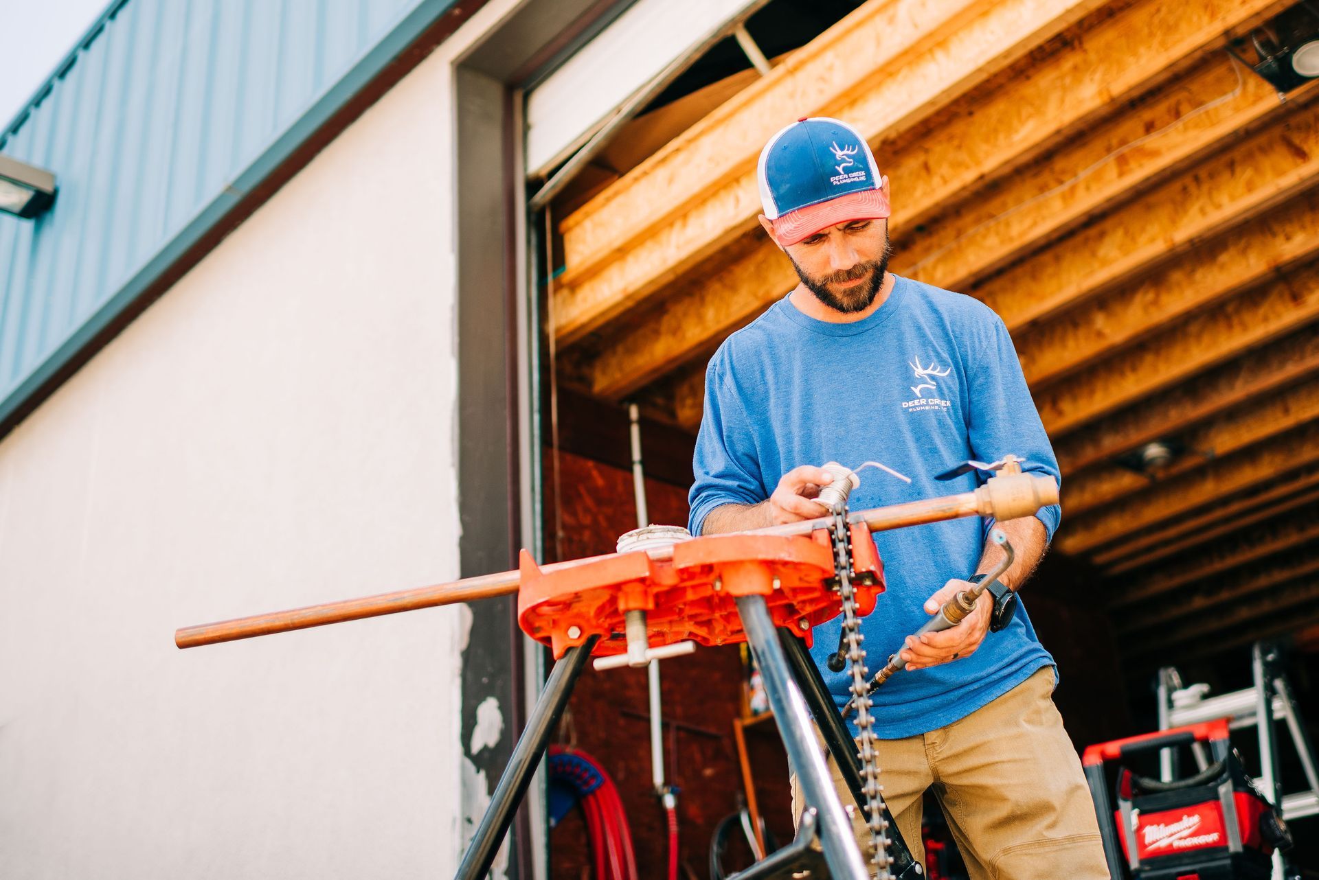 A man is cutting a pipe with a pipe clamp.