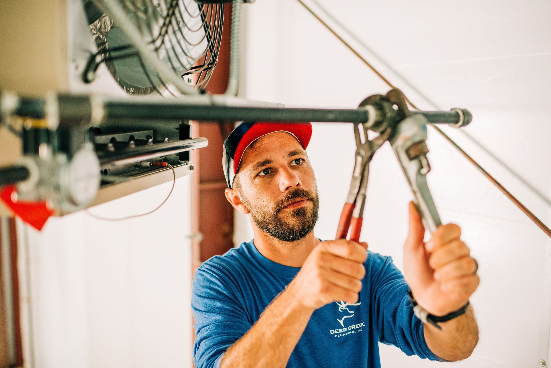 A man is fixing a pipe with a wrench.