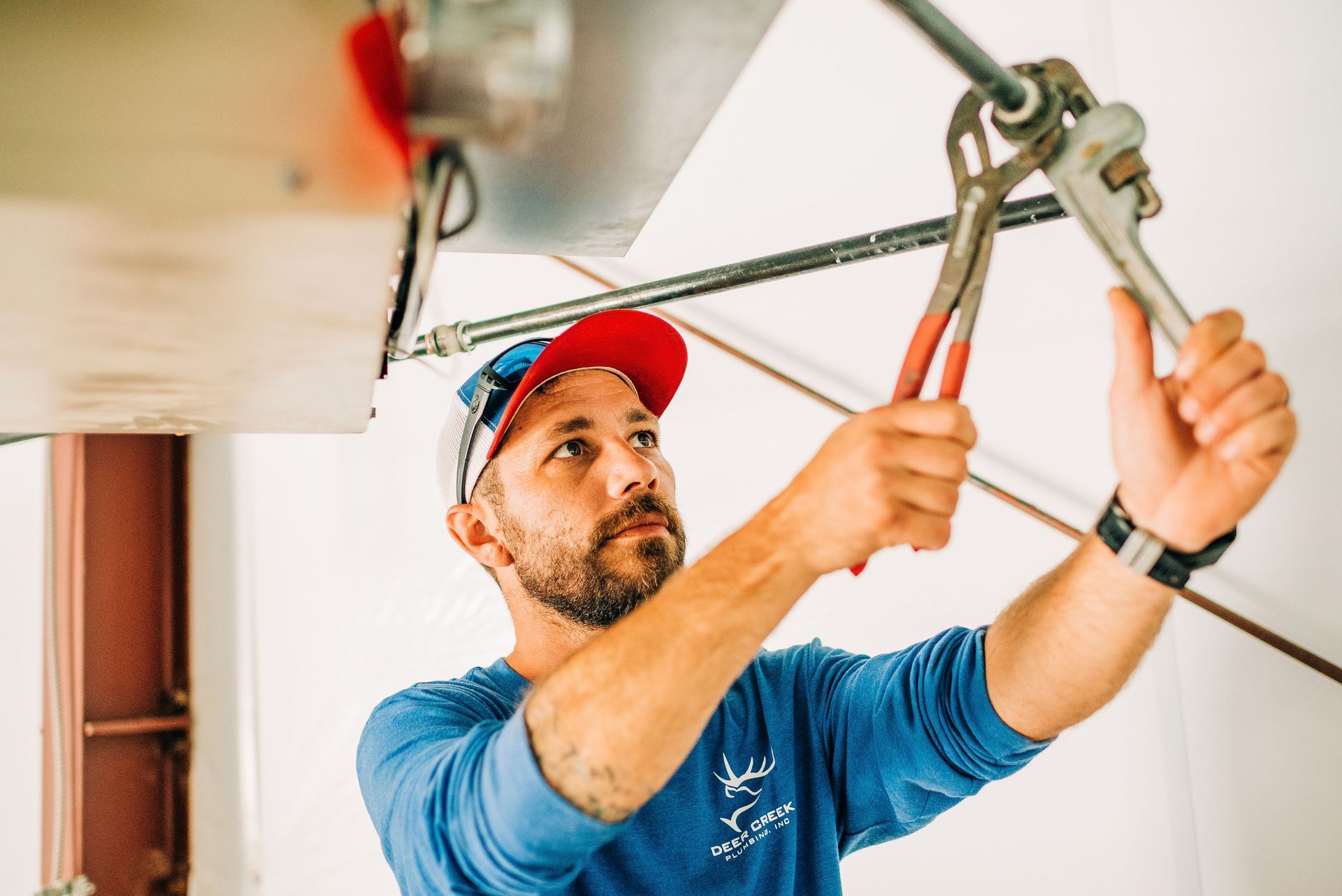 A man is working on a garage door with a wrench.