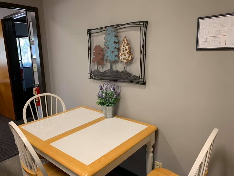 Small dining table with two chairs, metal tree wall art, lavender, gray wall.