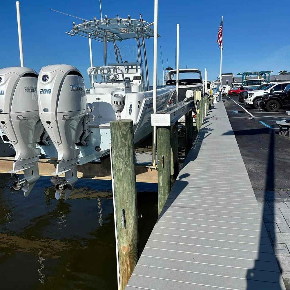A boat with two outboard motors is docked at a dock