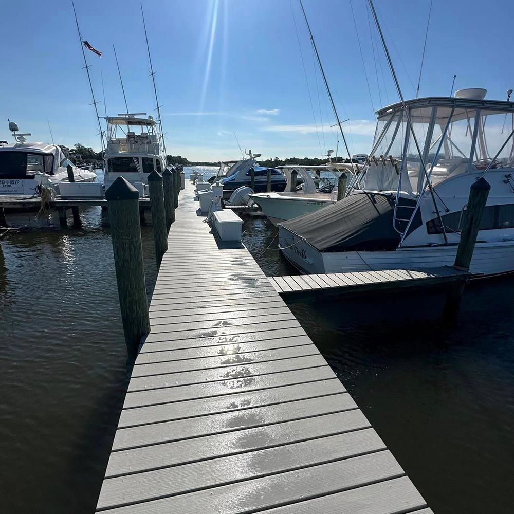 A dock with boats docked at a marina on a sunny day
