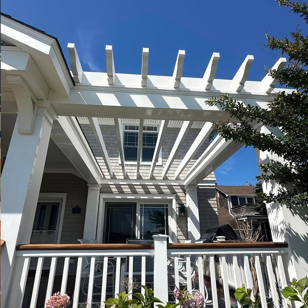 A house with a white pergola on top of it