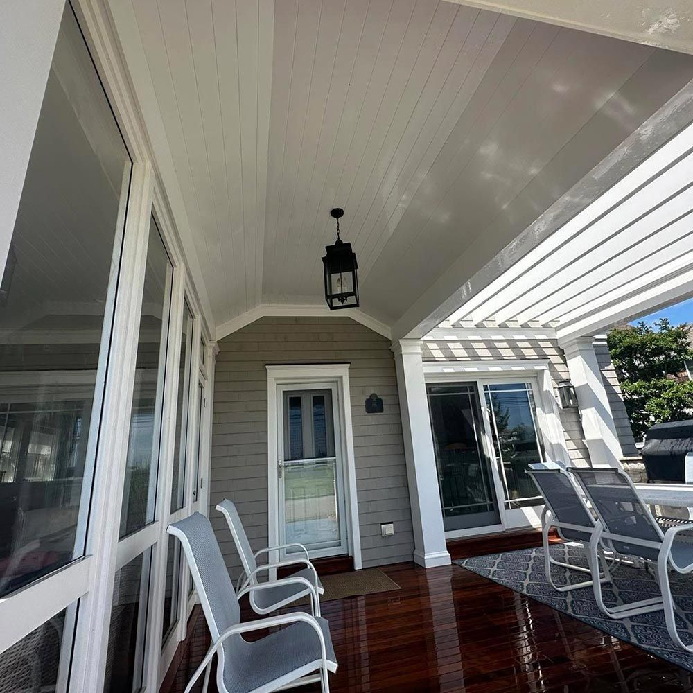 A porch with chairs and a lantern hanging from the ceiling