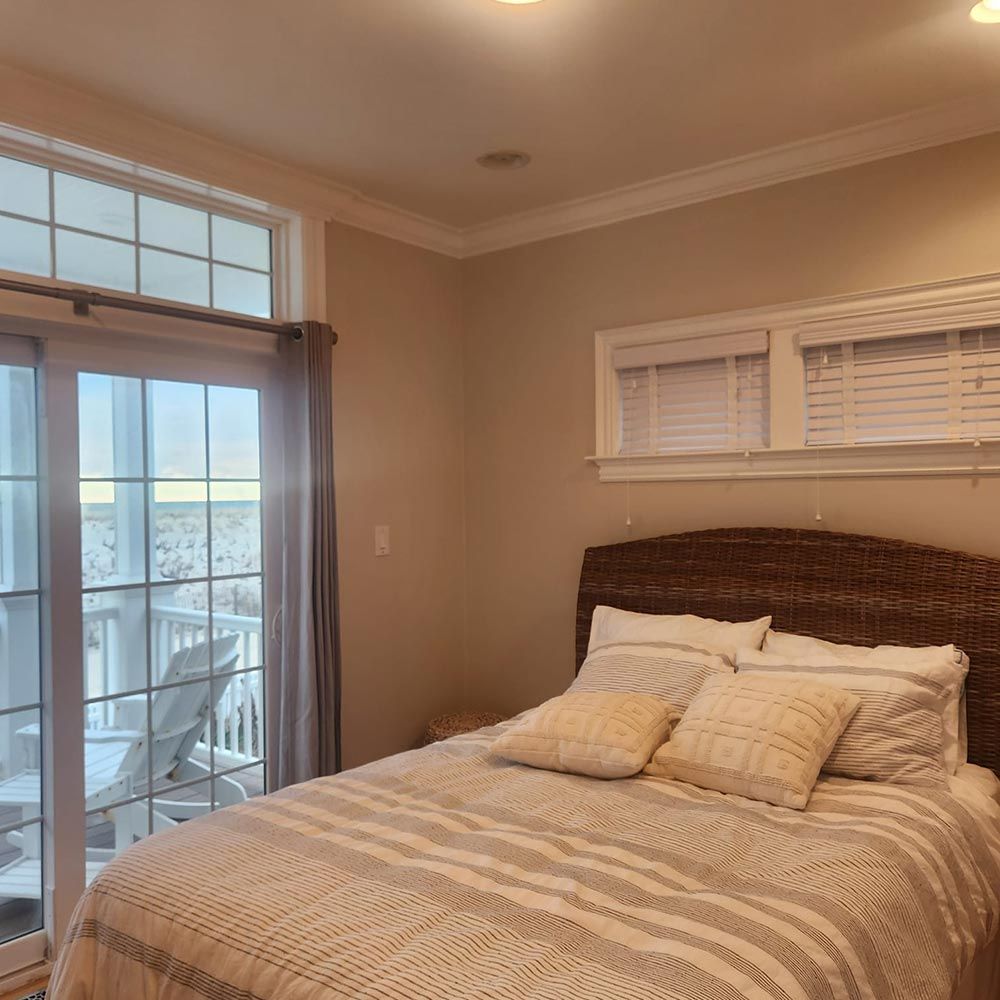 A bedroom with a large bed and a sliding glass door