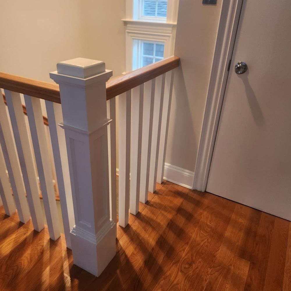 A staircase with a white railing and a wooden handrail