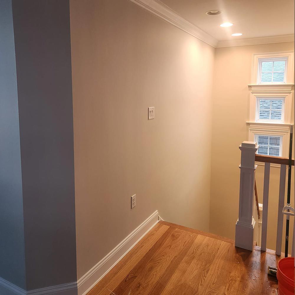 A hallway with hardwood floors and stairs in a house.