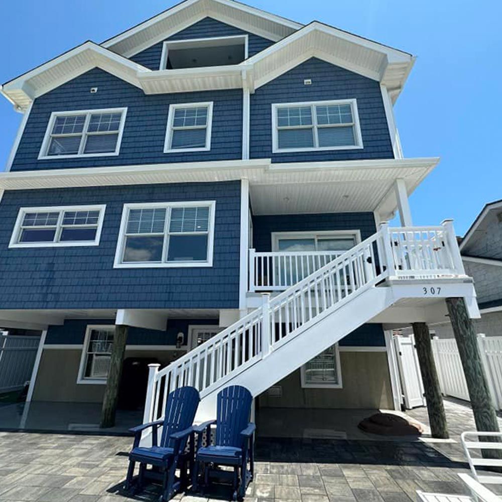A large blue house with stairs leading up to the second floor.