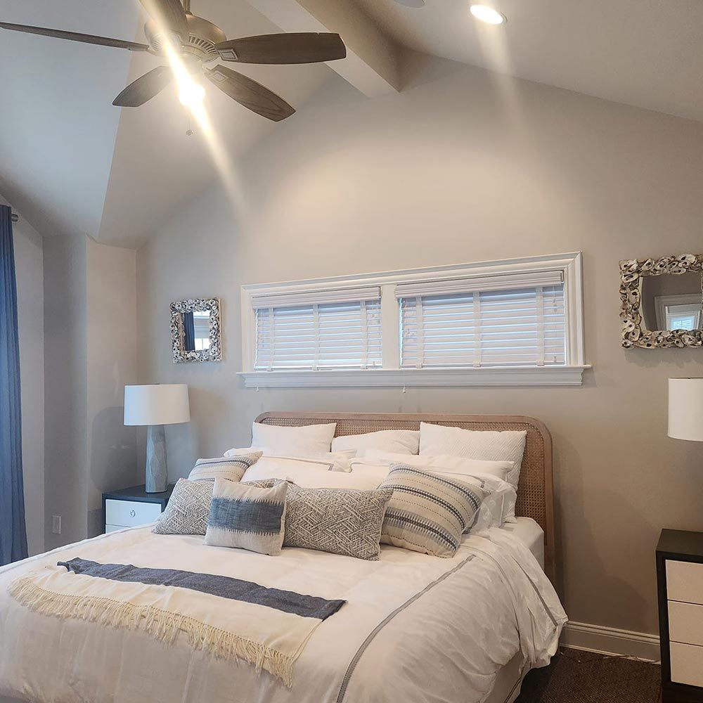 A bedroom with a large bed and a ceiling fan