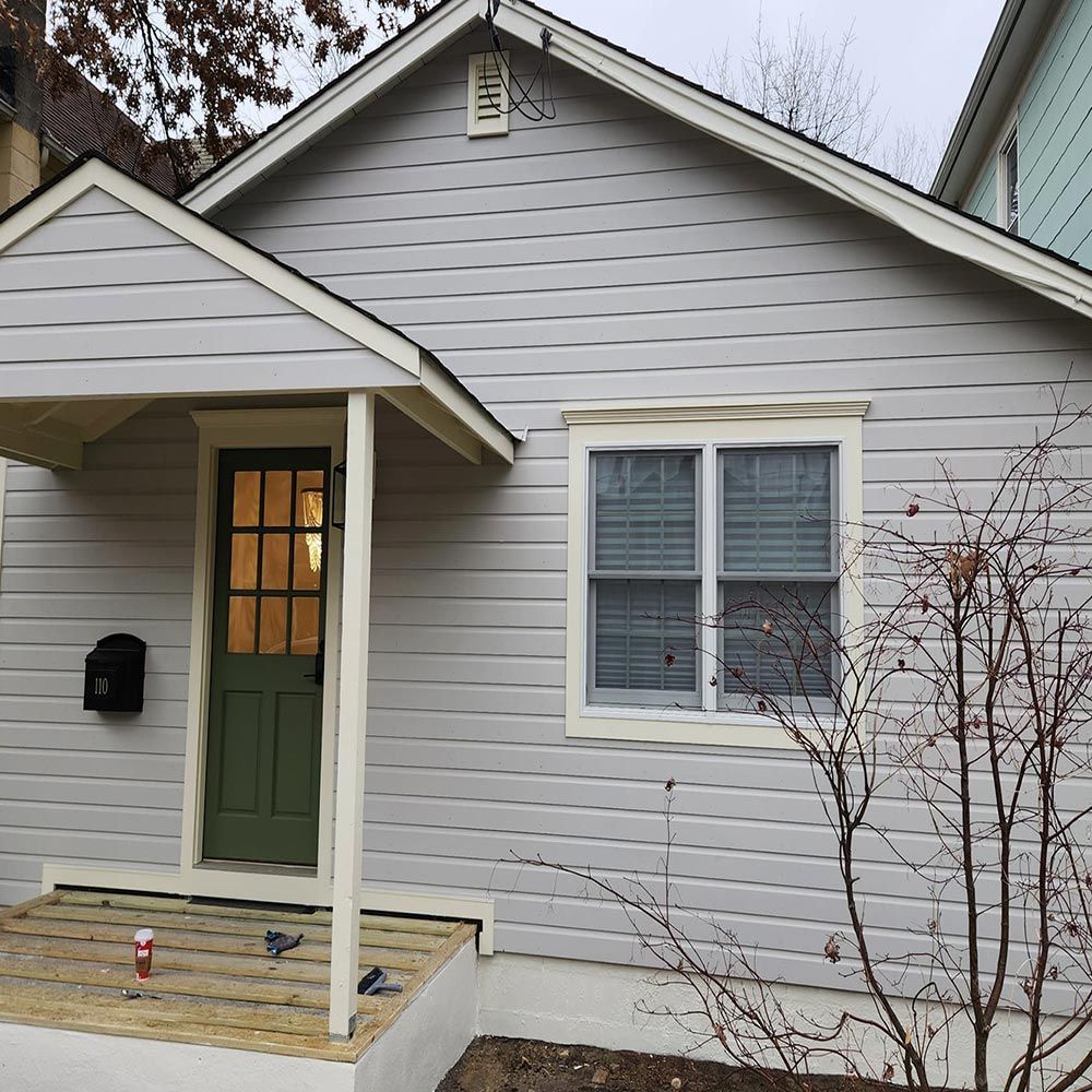 A small house with a green door and a mailbox